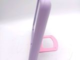 a purple cell phone sitting on a stand on a white surface