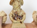 a ceramic figurine of a man sitting on a bench