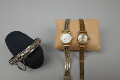 deux montres pour femme et un bracelet présentés dans une vitrine
