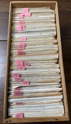 an open box filled with lots of papers sitting on top of a wooden table