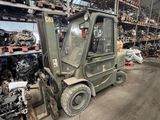 un chariot élévateur dans un grand entrepôt rempli de bric-à-brac