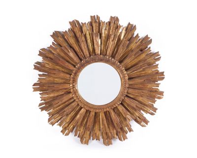 un miroir doré à rayons de soleil accroché à un mur blanc