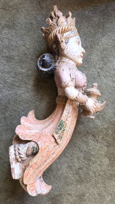 une figurine représentant une femme assise sur une étagère