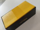 yellow and black box on a white table with a black lid