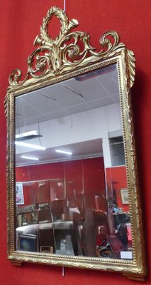 un miroir accroché au mur rouge d'une pièce