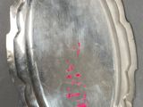 a silver plate with a pink writing on it