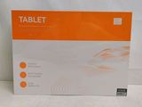 une boîte orange et blanche contenant une tablette, posée sur une surface blanche