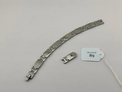 un gros plan d'un bracelet en métal auquel est attachée une étiquette