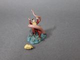 a figurine of a man riding a wave on a surfboard