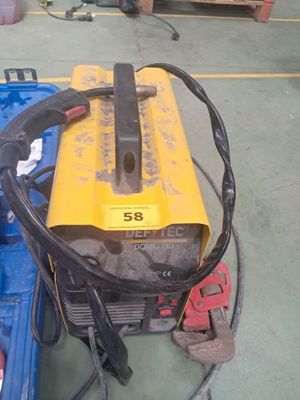 un équipement de soudage jaune et noir posé sur une mallette bleue