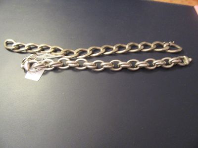 a silver chain with a tag on it on a table