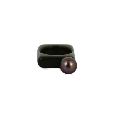 a black ring with a pearl in it on a white surface
