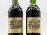 two bottles of wine sitting next to each other on a white surface