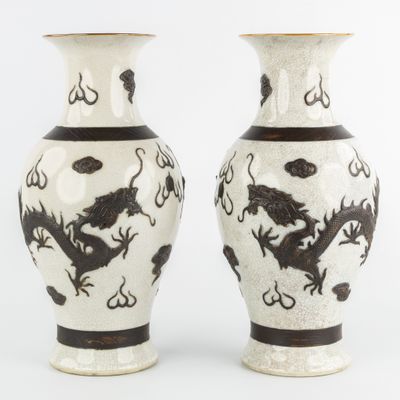 une paire de vases noirs et blancs ornés de motifs de dragons