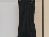 La robe noire est suspendue à un portant dans une pièce.