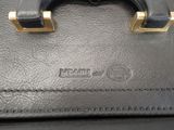 a close up of a black bag with a gold handle