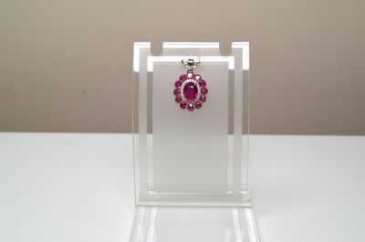 vitrine à bijoux en acrylique transparent sur laquelle est posée une paire de boucles d'oreilles