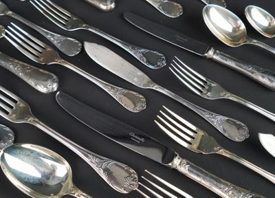 many spoons and forks laid out on a table