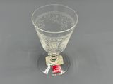 a wine glass sitting on top of a coaster on a table