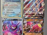 Quatre cartes Pokémon différentes sont posées sur une table.