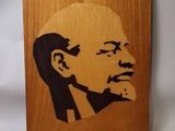 a close up of a wooden plaque with a picture of a man ' s face