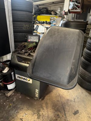 un tas de pneus dans un garage, à côté d'une machine