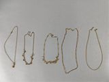 four different types of gold necklaces on a white surface