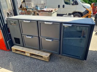 un réfrigérateur posé sur une palette devant une camionnette