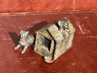 une petite niche sur laquelle sont posées des figurines représentant un chien et un chat