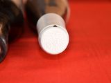 two bottles of wine sitting on a red cloth