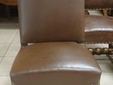 pair of brown leather dining chairs in a store with a white tile floor