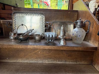 de nombreux objets en argent posés sur une étagère en bois