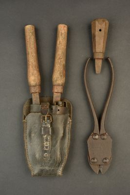 pair of old garden tools on a gray surface with a wooden handle