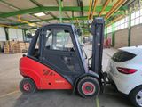 a forklift truck parked next to a car in a warehouse