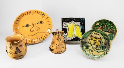 de nombreux objets en poterie posés sur une surface blanche