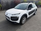 une Citroën blanche garée sur un parking près d'une clôture