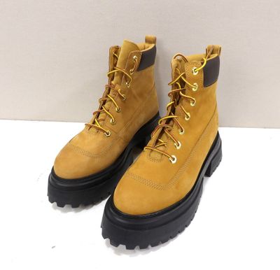 une paire de bottes jaunes posées sur une surface blanche