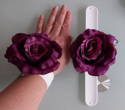 a person holding two purple flowers in their hands