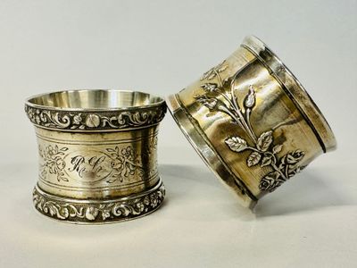 pair of silverplated napkin holders with floral designs on them