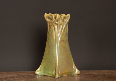 a green vase sitting on a table with a black background