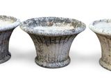 trois vases posés l'un à côté de l'autre sur une surface blanche
