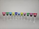 six verres à vin multicolores sont alignés en rangée