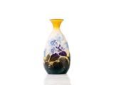 a yellow vase with blue flowers on it sitting on a white surface