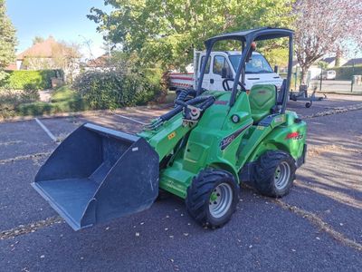 a small green tractor parked in a parking lot