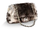 sac à main en fourrure marron et blanche avec une bandoulière en chaîne, sur fond blanc