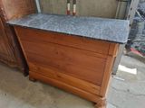 a wooden dresser with a granite top in a room