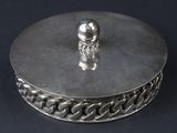 une boîte en argent sur laquelle trône une figurine en argent
