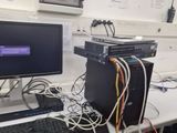 a desk with a monitor, keyboard, mouse, and other electronics on it
