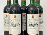 trois bouteilles de vin rouge posées l'une à côté de l'autre sur une surface blanche