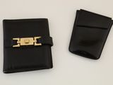 deux morceaux de cuir noir munis d'un fermoir en métal doré